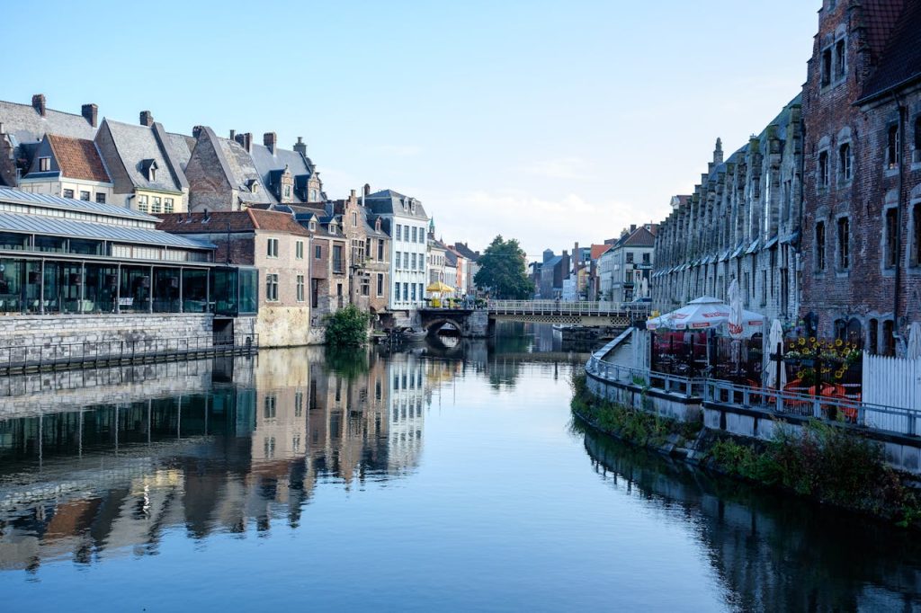 Picturesque canal scene in Ghent, Belgium, showcasing historic architecture and tranquil reflections.