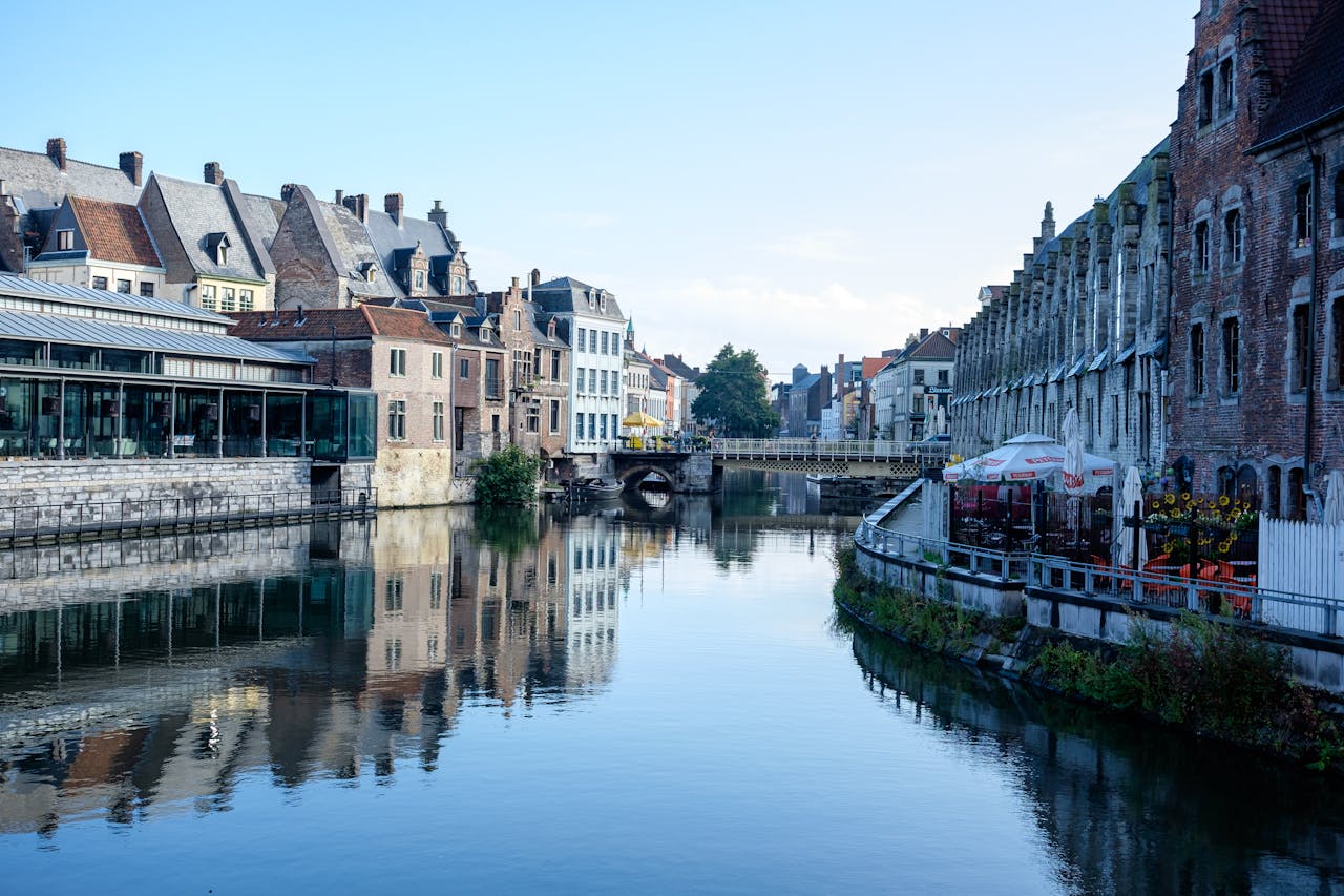 Picturesque canal scene in Ghent, Belgium, showcasing historic architecture and tranquil reflections.