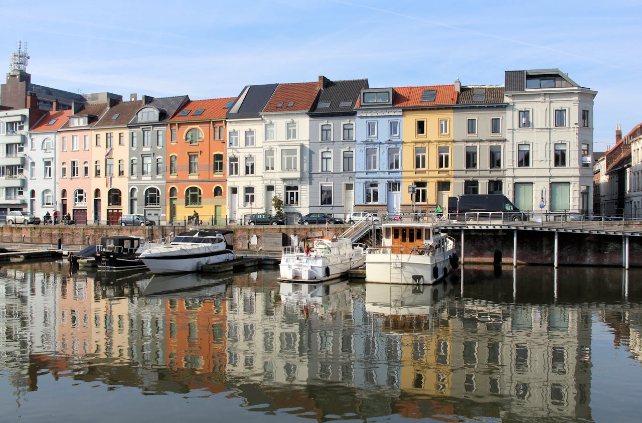 Vibrant reflection of historic buildings along a canal in Ghent, Belgium.